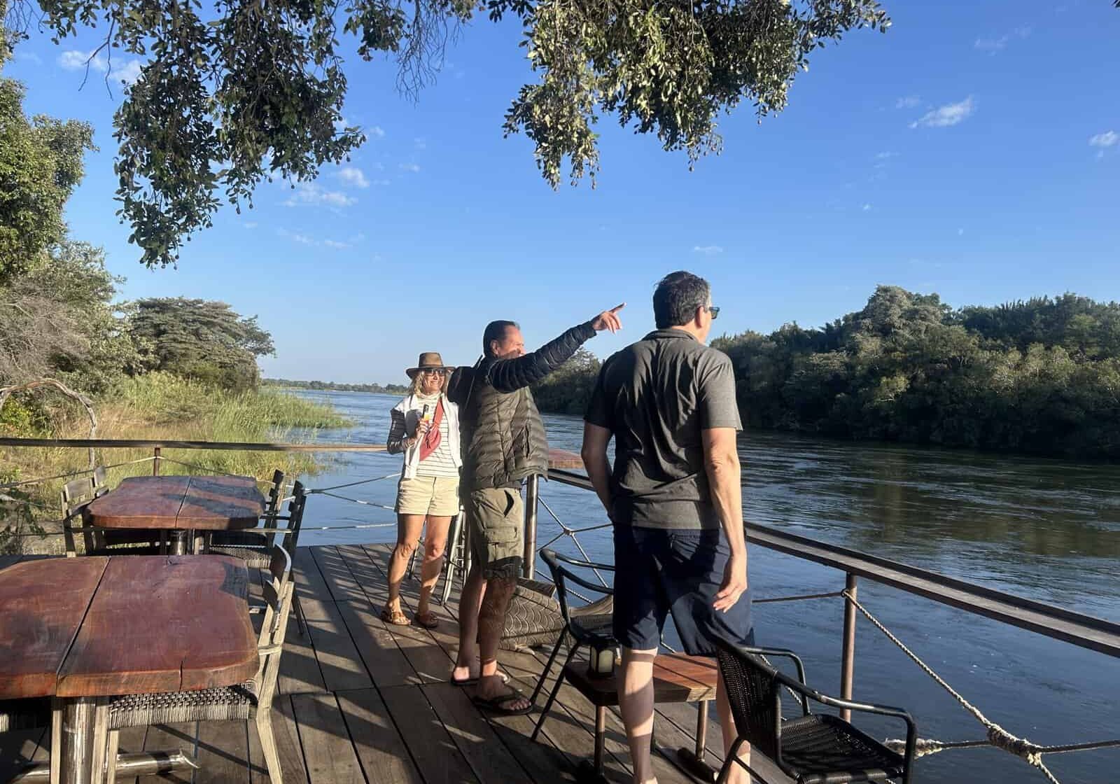 Family exploring wildlife during a safari boat tour in Africa.