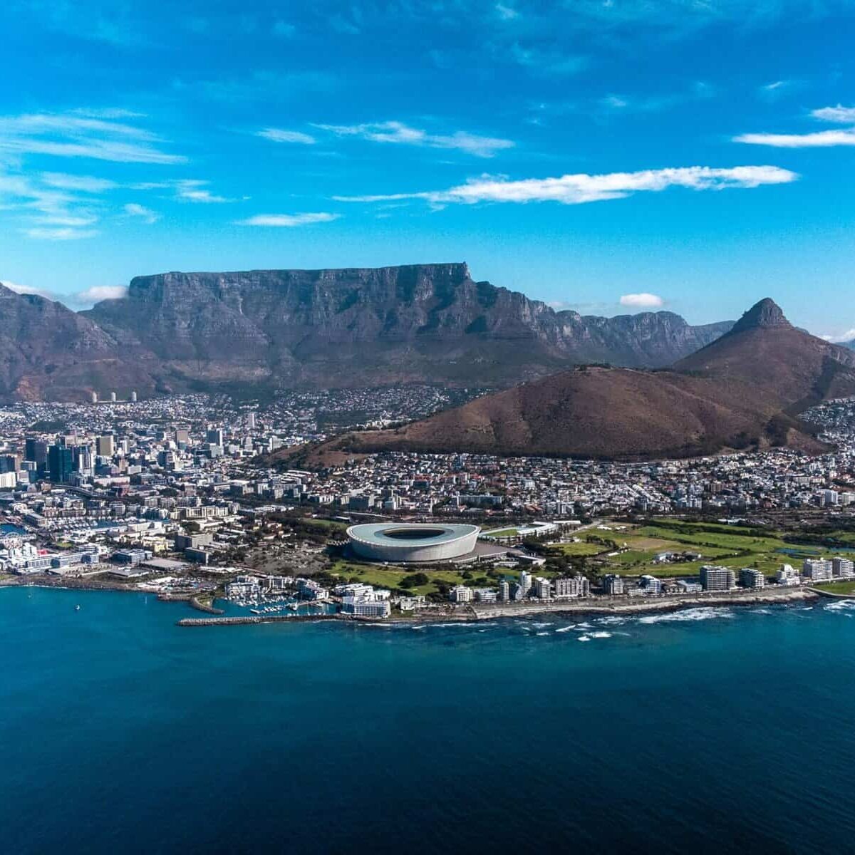 Aerial view of Cape Town with Table Mountain and Atlantic Ocean backdrop.